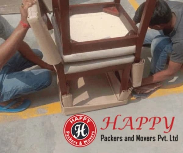 Crew wrapping wooden furniture before a house move